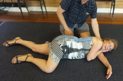Students demonstrating the stable side or recovery position in a community session in Brisbane, Australia.