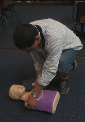 One of B-Ready First Aid's students in a community course checking if a casualty is responsive.