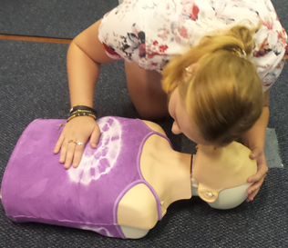 A student demonstrating the look, feel and listen and feel technique for assessing a casualties breathing status @ a community training session for B-Ready First Aid.